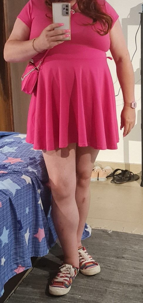 Short pink dress, rainbow shoes, long red hair